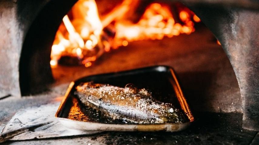fish in front of wood fire oven